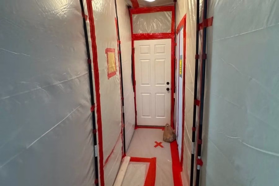 Professional mold remediation containment setup in residential hallway