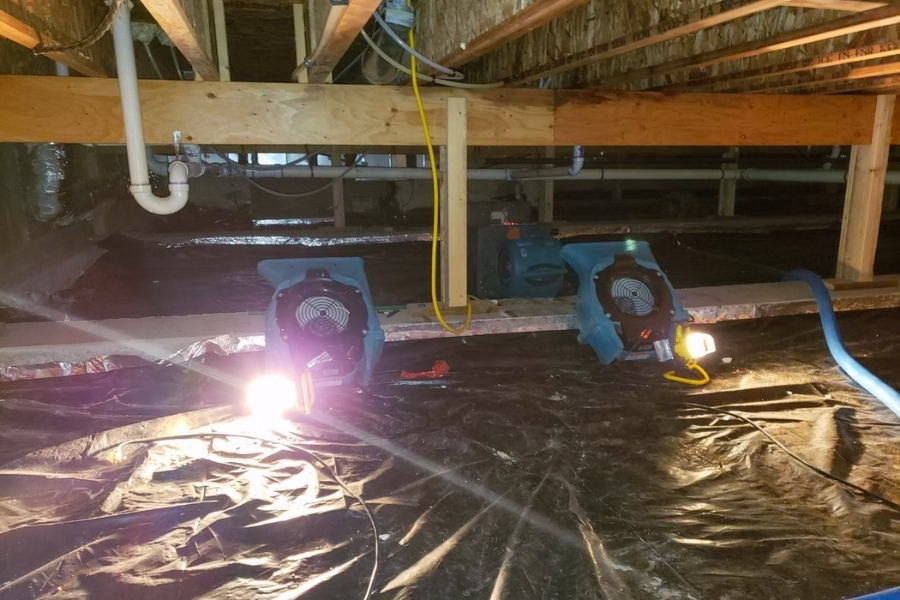 Professional air movers set up inside a crawl space to dry out moisture