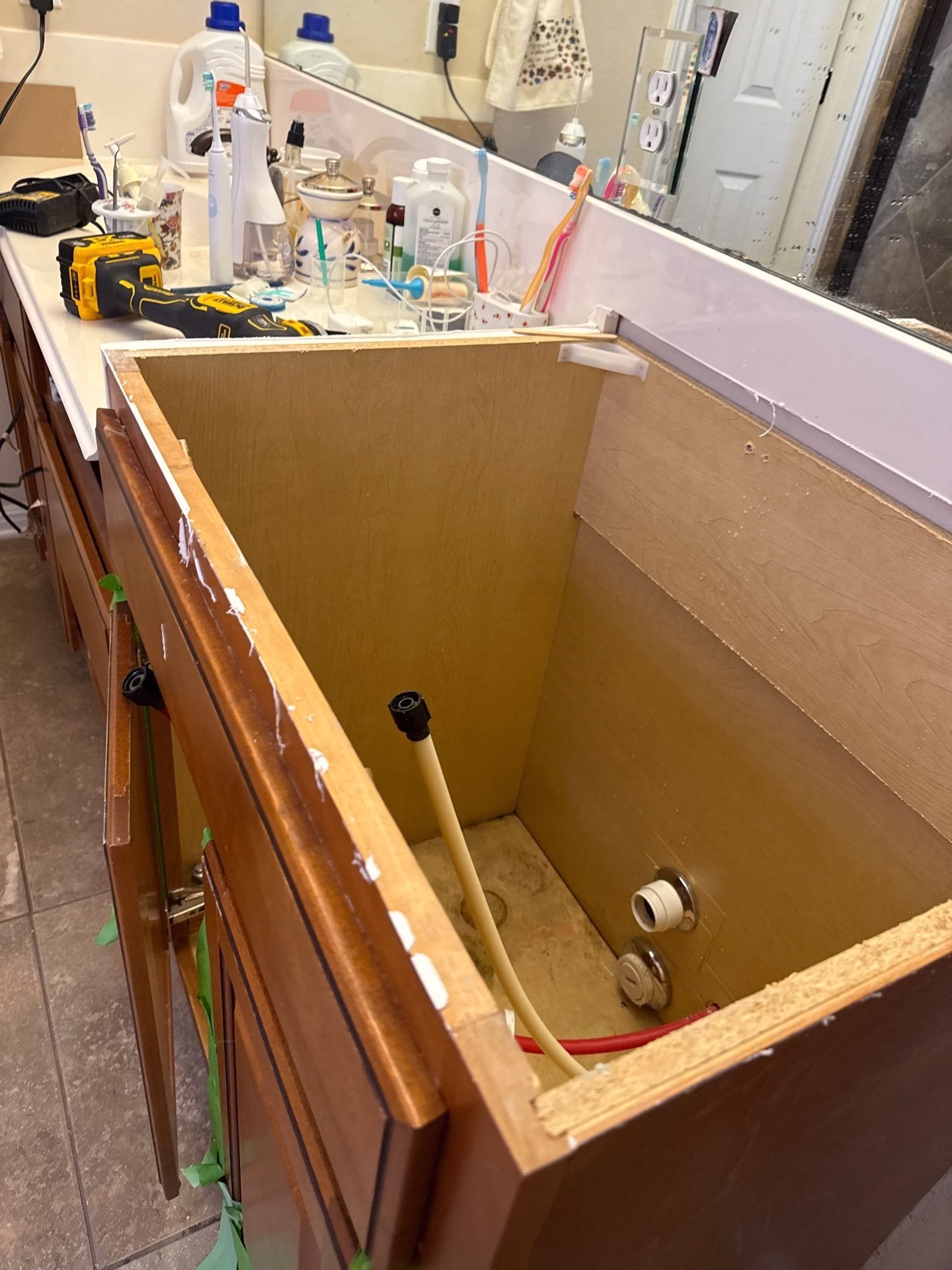 Bathroom cabinet opened for inspection and cleaning during mold restoration