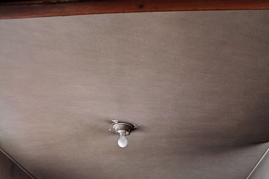 Ceiling with smoke discoloration around a bare light fixture after a house fire in Austin TX