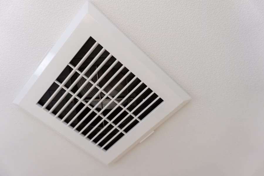 Ceiling-mounted bathroom exhaust fan vent venting humid air out of a home in Austin TX