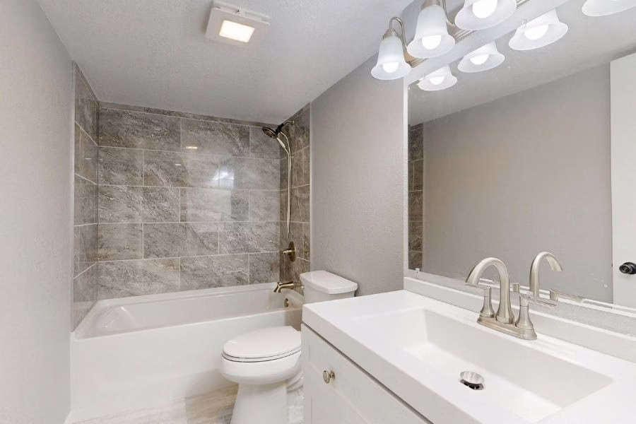 Restored bathroom with new tile flooring and fresh baseboards, before-and-after quality, in an Austin residential home