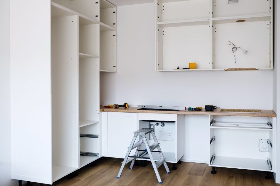 Restored kitchen with new lower cabinets and flooring after water damage repair, clean and bright residential setting