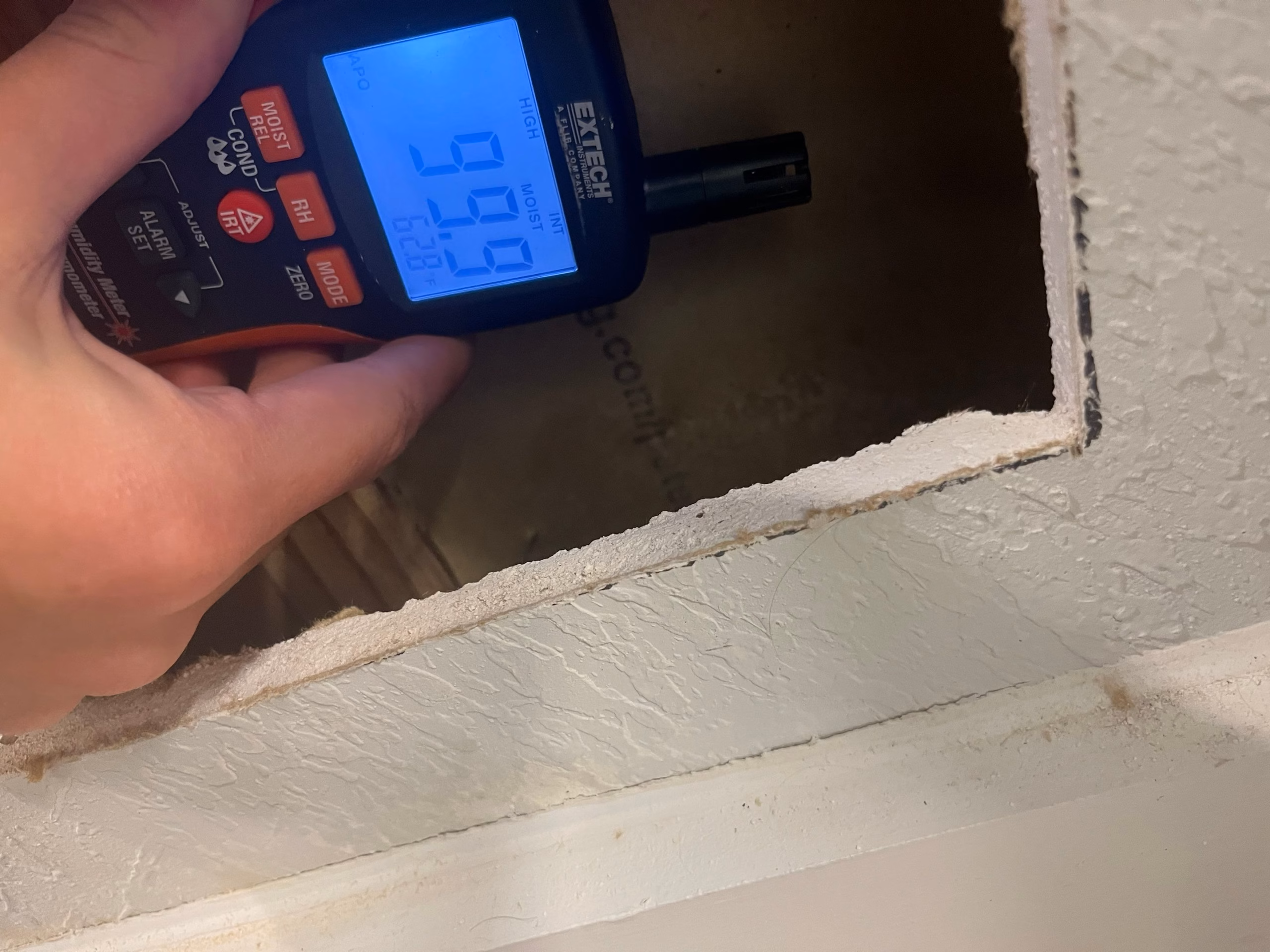 Moisture meter reading on a water stained bathroom wall during damage assessment in Austin, TX