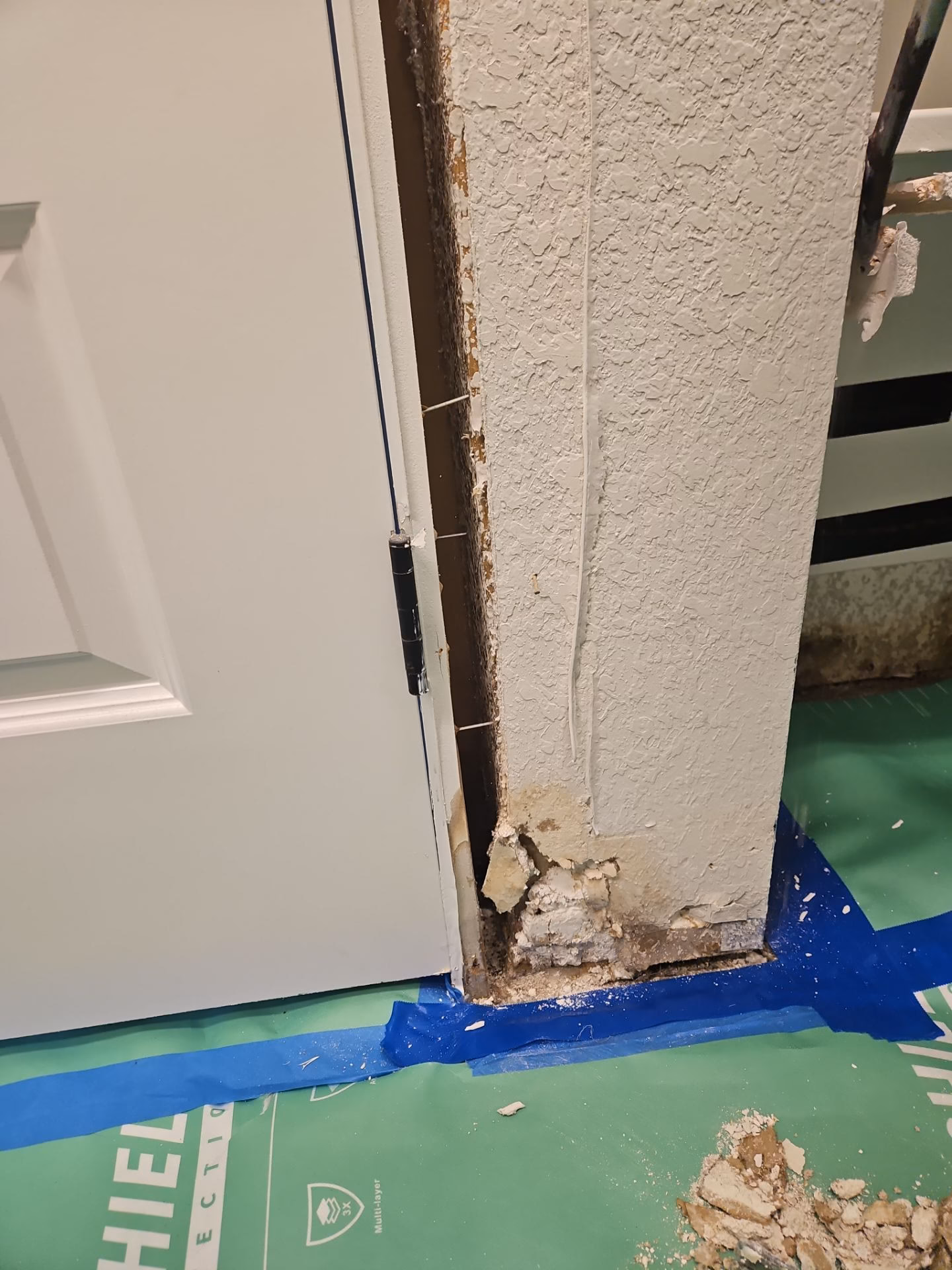 Water damaged door jamb removed during controlled demolition in an Austin home