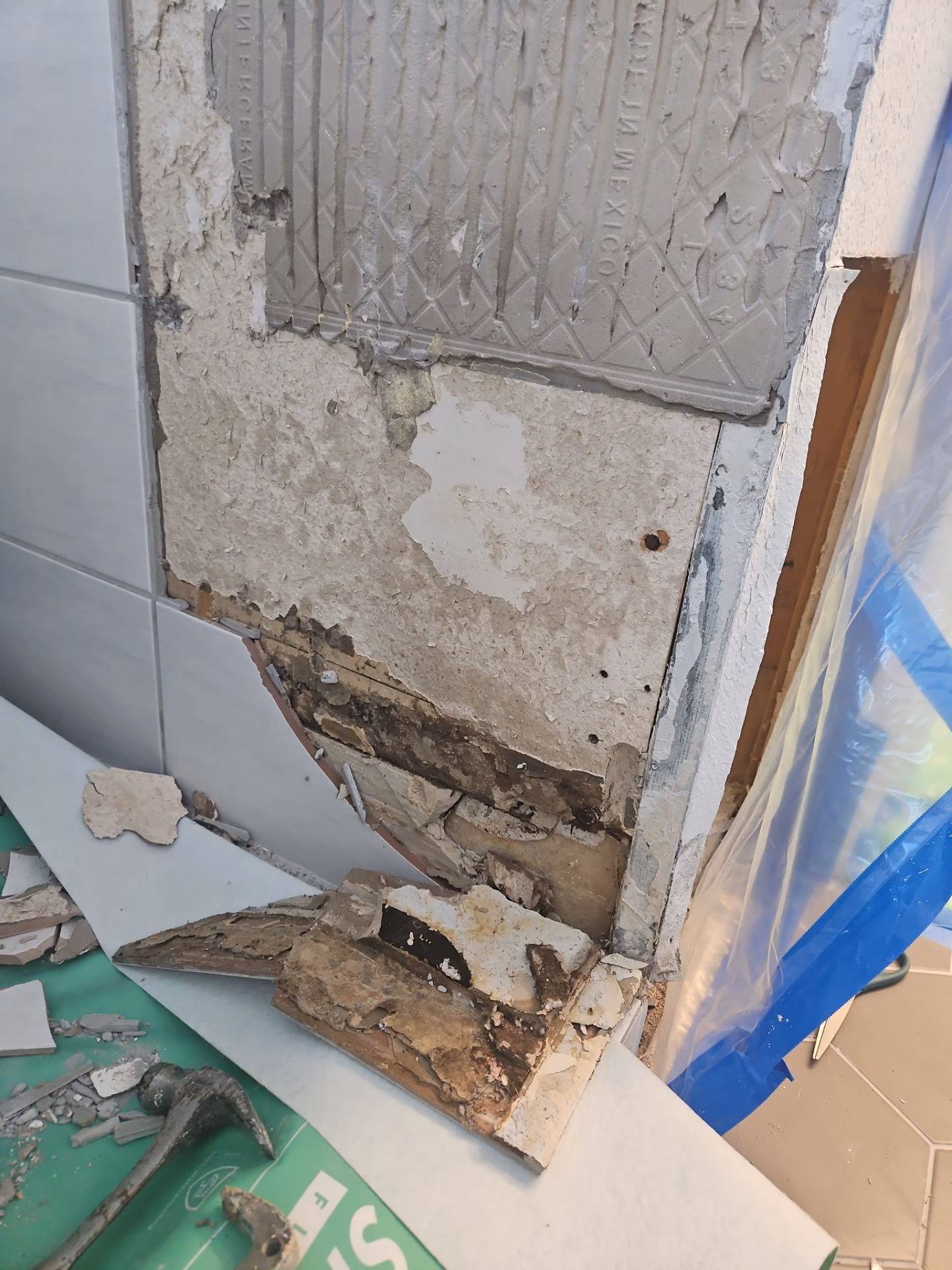 Shower tile removal revealing rotted substrate underneath after long term water leak