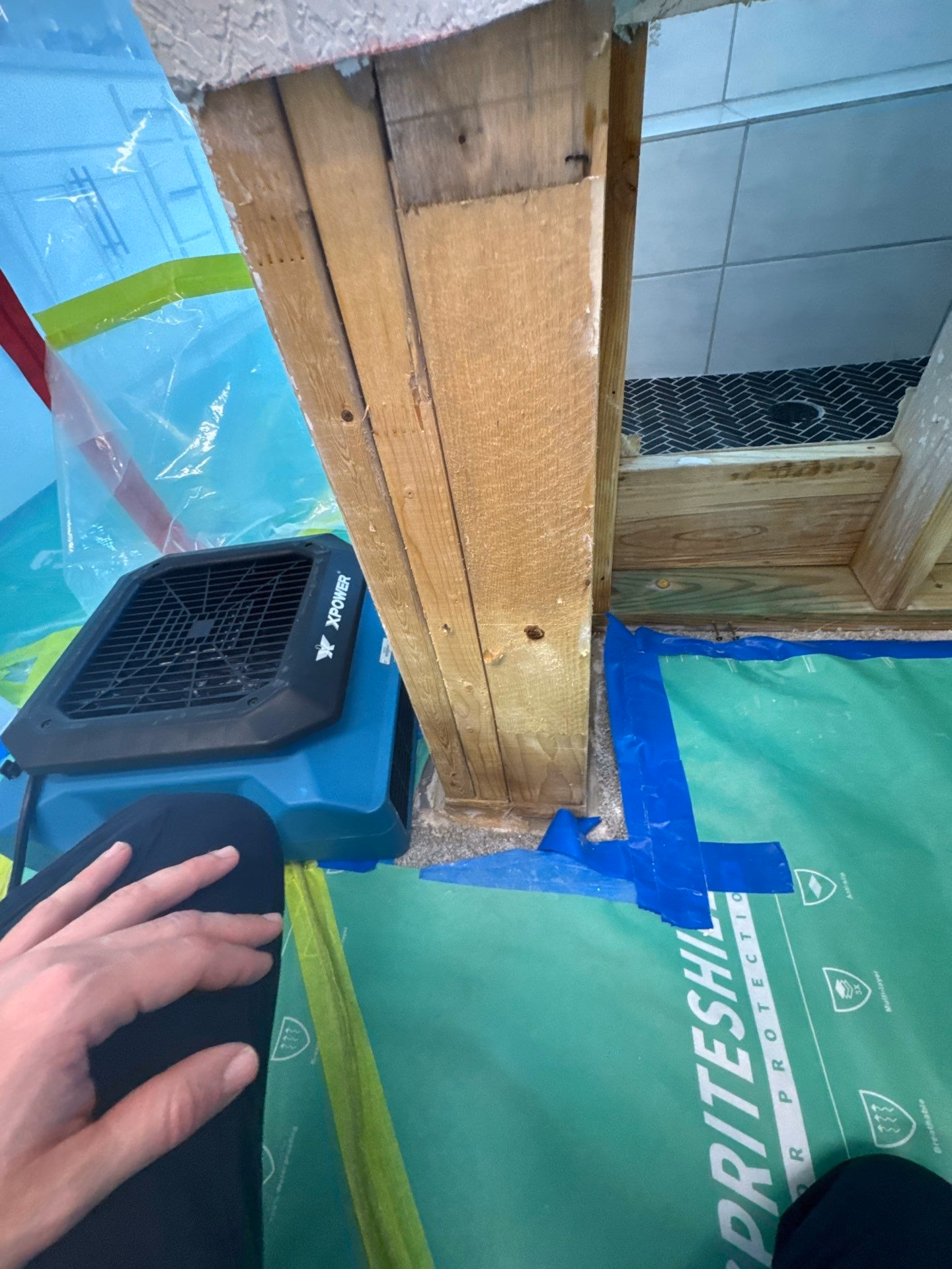 Commercial air mover drying exposed wall structure after demolition
