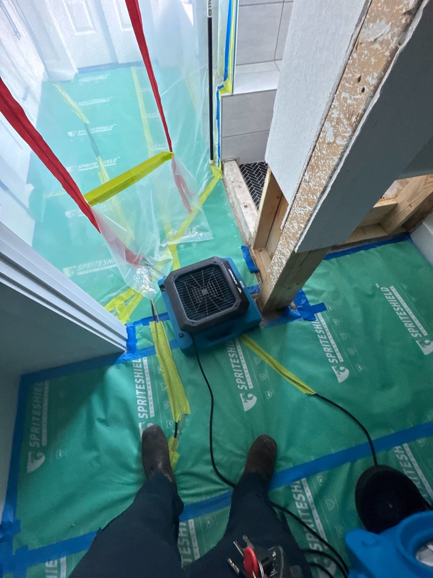 Full containment with commercial drying equipment running in the bathroom work zone