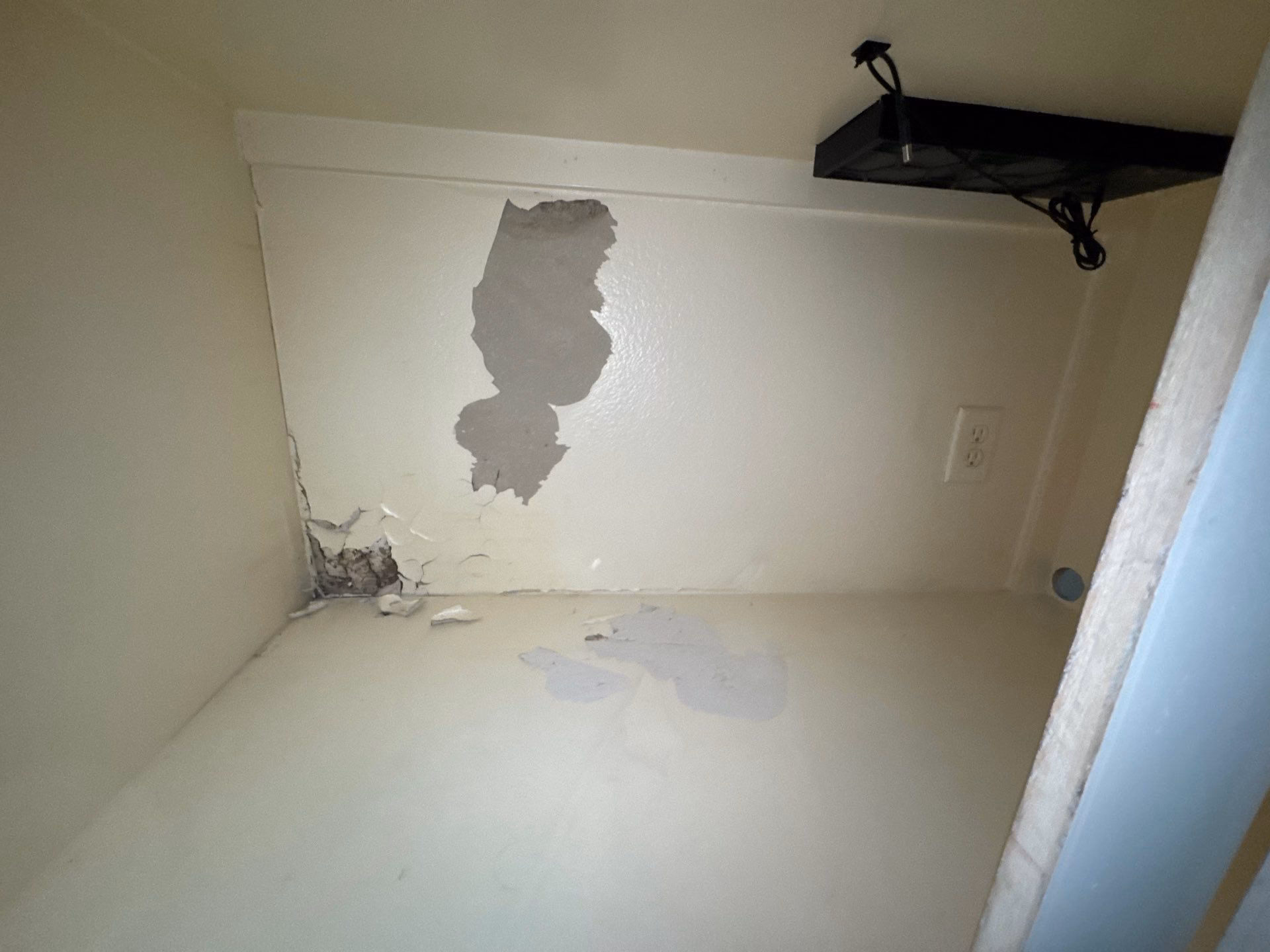 Brown water staining spreading across a wall corner in a Round Rock home before restoration