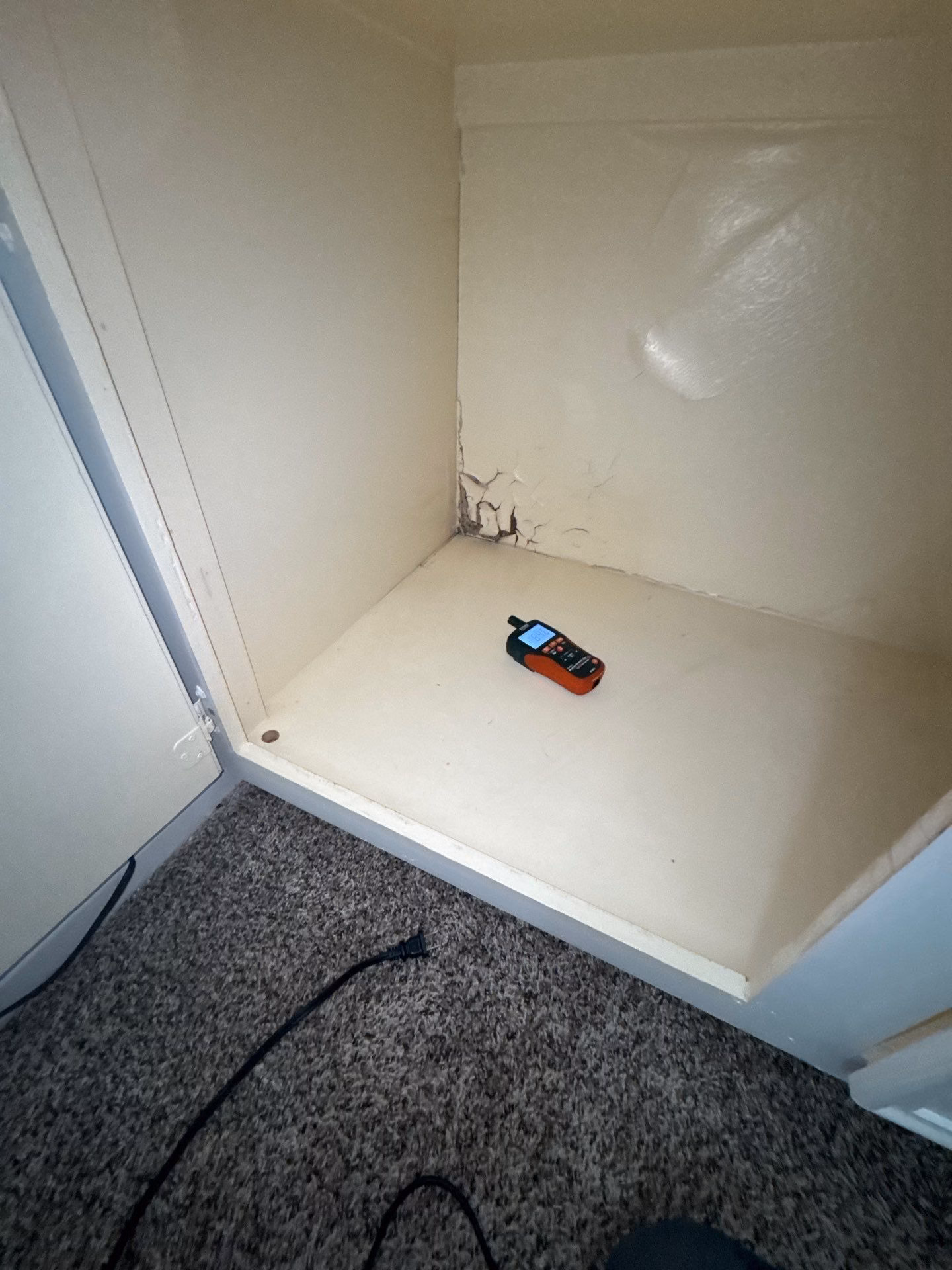 Peeling and blistered paint inside a water damaged closet from prolonged moisture exposure
