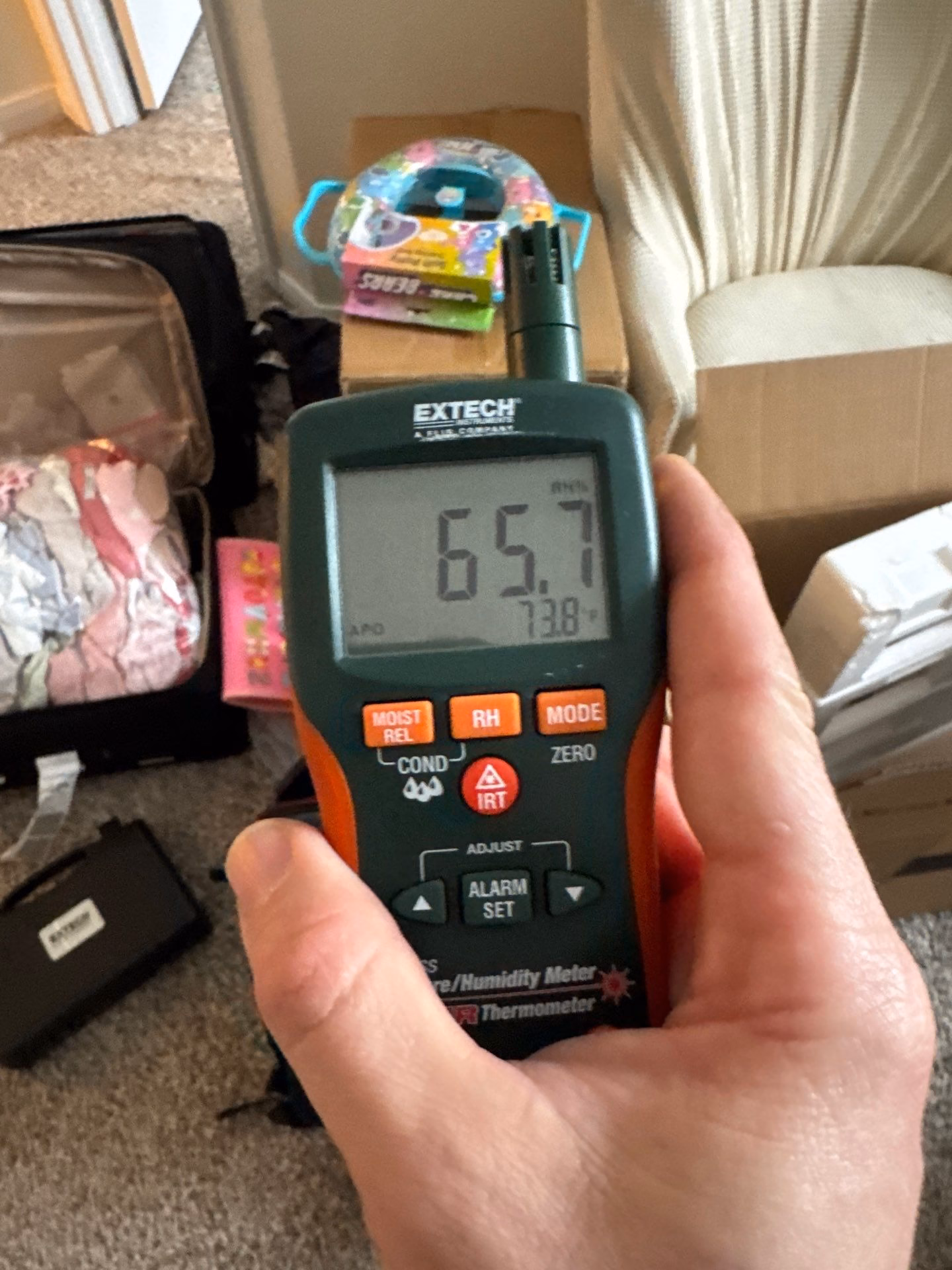 Moisture meter showing an elevated reading inside the wall during the water damage inspection