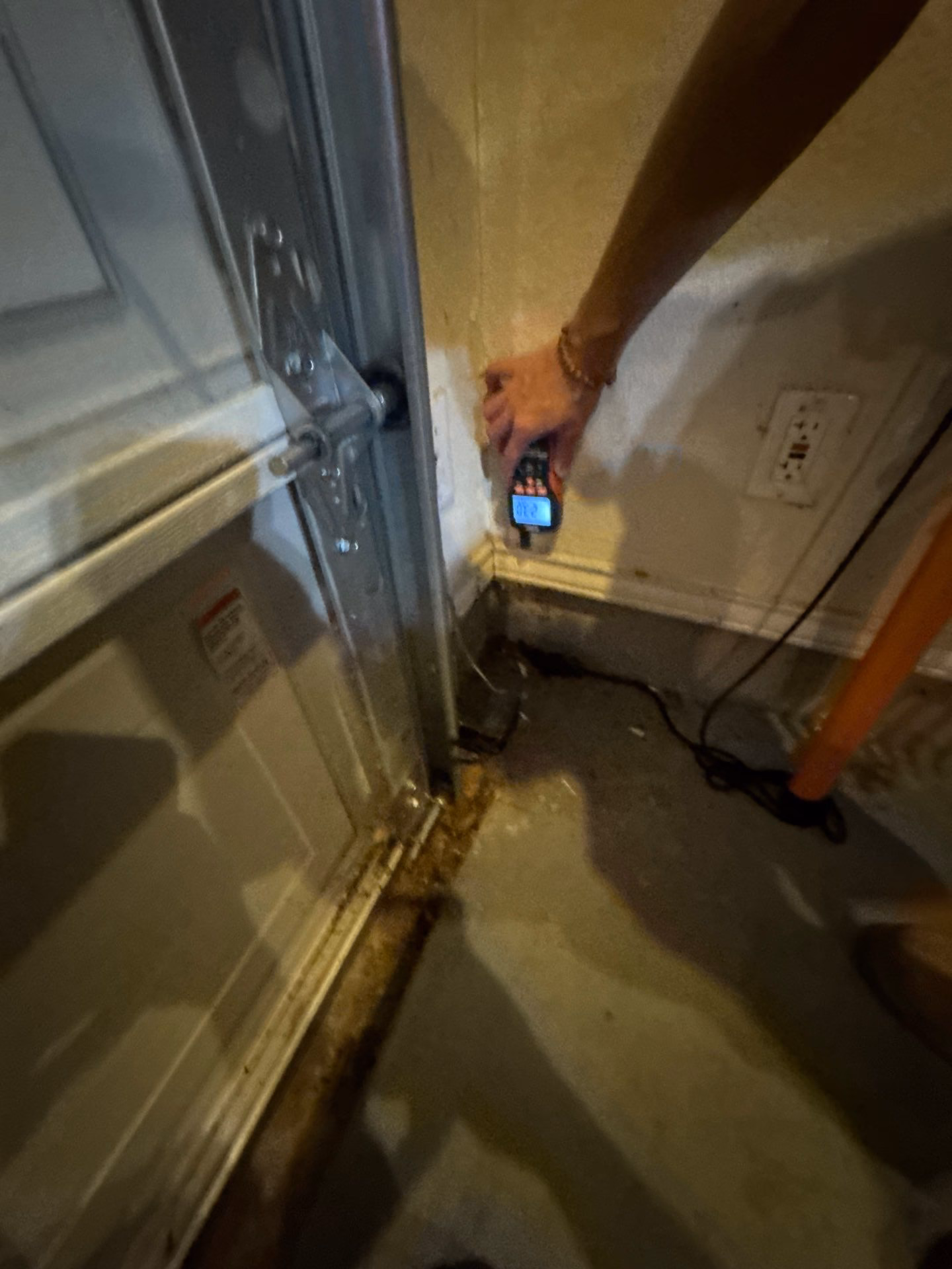 Austin Fire and Flood technician checking moisture levels at a doorway during the drying process